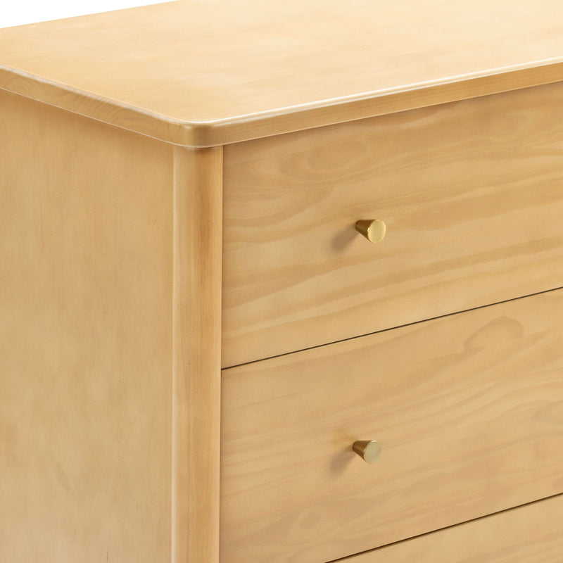 Minimalist natural wood three-drawer dresser with rounded edges and brass knob pulls, light pine finish modern bedroom storage