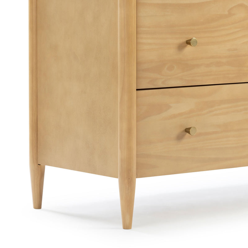 Close-up of mid-century modern natural pine wood dresser corner with tapered legs, two drawers and round brass knobs