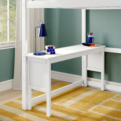 White loft bed with integrated study desk, blue desk lamp, Rubik-style cubes and colored pencils in cup against teal wall on yellow geometric rug