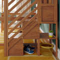 Modern wooden staircase with diagonal slat railing and built-in under-stair shelving holding blue sneakers, yellow wire basket and potted succulent in a bright entryway