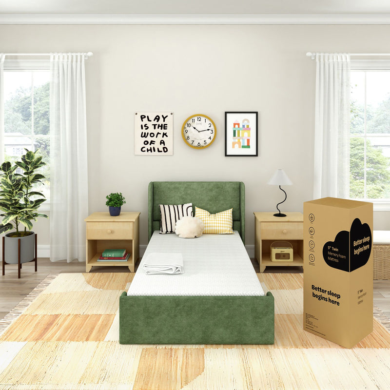 Kids' bedroom with green upholstered twin bed and mattress-in-a-box memory foam, light wood nightstands, wall art, clock, and indoor plant