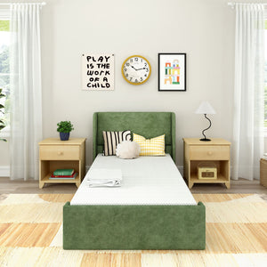 Modern children's bedroom with green upholstered twin bed, light wood nightstands, wall clock, framed art, decorative pillows and white curtains