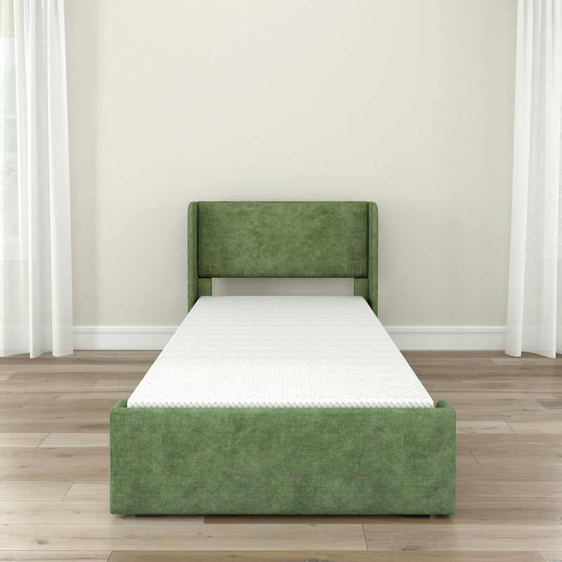 Green upholstered single bed frame with white mattress in a minimalistic bedroom setting.