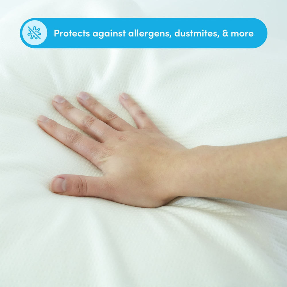 Hand pressing on an anti-allergen mattress protector, safeguards against dust mites and allergens.