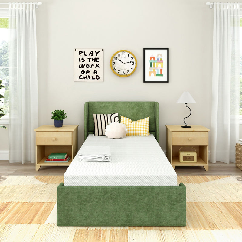Modern kids bedroom with green upholstered twin bed, light wood nightstands, patterned pillows, wall clock and "Play is the Work of a Child" wall art