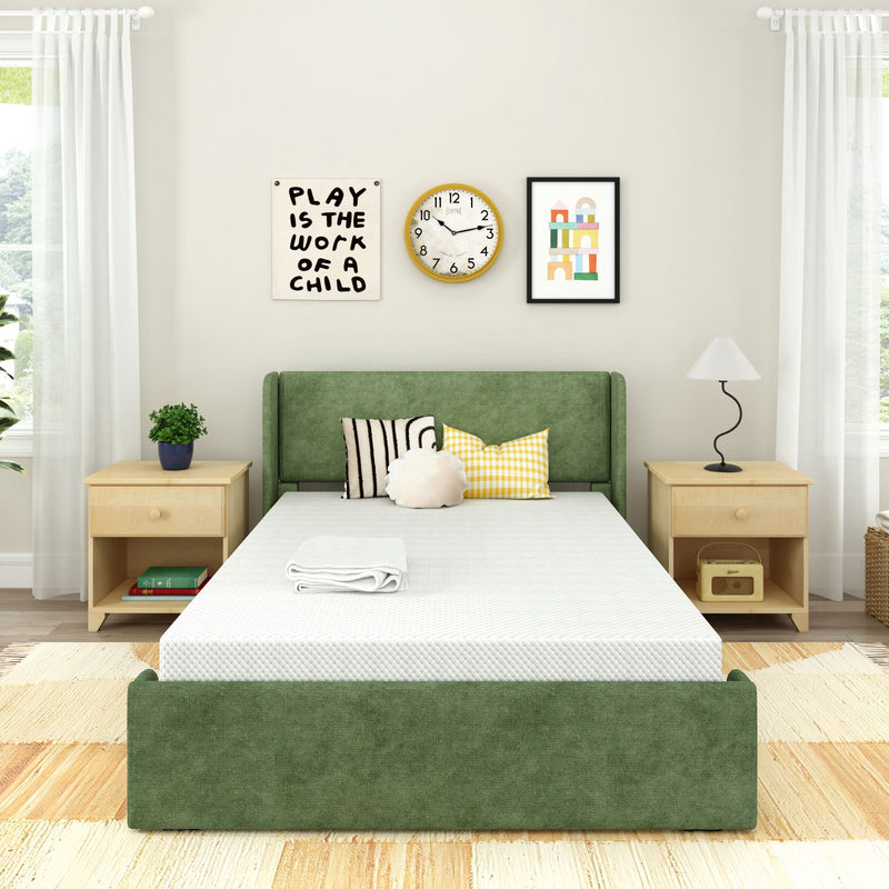 Bright minimalist bedroom featuring a green upholstered platform bed with white mattress, wooden nightstands, decorative pillows, wall clock and framed children's artwork reading "Play is the work of a child