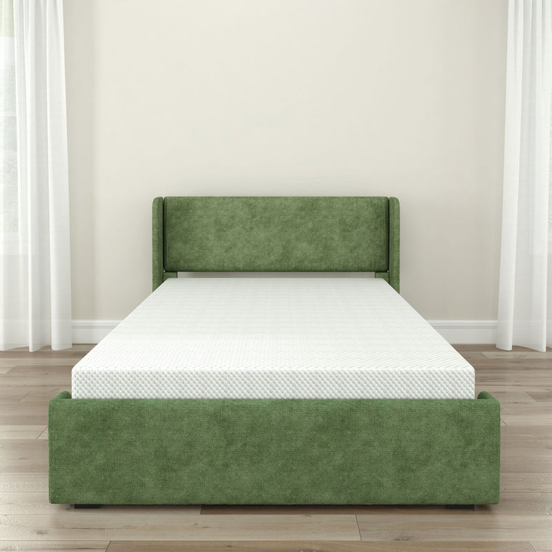 Green upholstered bed frame with white mattress in a bright bedroom.