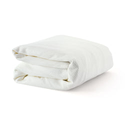 Folded white cotton blanket on a white background for bedding and home decor.