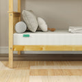 8-inch gel memory foam mattress on light wood platform bed with neutral pillows, bolster, and beige area rug