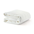 Folded white waffle-knit cotton throw blanket on white background, soft breathable bed and sofa blanket for home decor