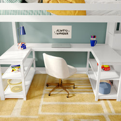 Kids loft bed workspace with white built-in L-shaped desk and white swivel chair, closed laptop, blue desk lamp, colored pencils in a mug, toy blocks on shelves and a yellow patterned rug