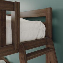 Close-up of solid wood loft bunk bed in dark walnut finish with ladder and white comforter against a teal bedroom wall