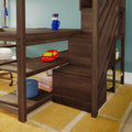 Wooden study desk with built-in shelves and storage, blue mug of colored markers, red toy car, books and lamp on yellow rug in a child's room