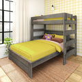 Gray wooden bunk bed with bright yellow bedding and flower pillow in a sunlit kids' bedroom with yellow plaid wallpaper.