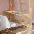 Small home office with light wood wall desk, silver laptop, pink desk lamp and white swivel chair against pink wallpaper