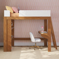 Wooden loft bed with built-in desk, white swivel chair, pink desk lamp and pastel pillows against pink scallop wallpaper in a modern kids’ bedroom