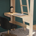 Minimal home office: wall-mounted light wood desk with black modern table lamp, closed silver laptop, black ergonomic swivel chair on patterned rug against teal wall