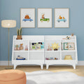 Modern white kids bookshelf toy organizer for nursery and playroom with children's books, wooden toys and storage bins against a blue accent wall topped by three framed watercolor animal car prints, floor lamp, orange pouf and soft rug — nursery storage and playroom decor