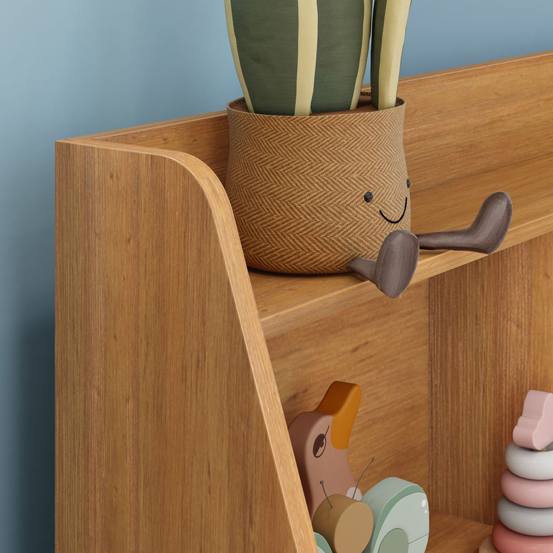 Smiling woven plant pot on wooden nursery shelf with wooden duck pull-toy and pastel stacking rings