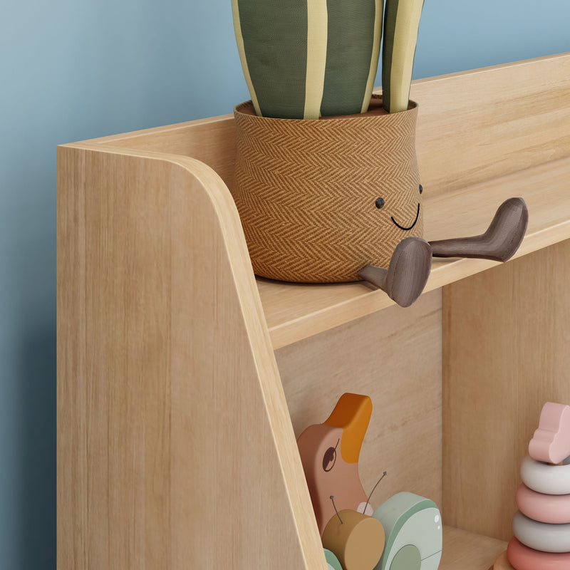 Nursery wooden bookshelf with smiling woven planter, striped plant, pastel stacking rings and wooden pull-along duck toy for kids room decor