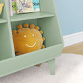 Smiling sun plush pillow on mint green kids bookshelf in bright nursery with children's books, white shag rug and hardwood floor