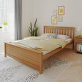 Scandinavian bedroom with wooden bed frame, neutral yellow bedding, spotted throw pillow, indoor plants, fruit wall art and natural light.