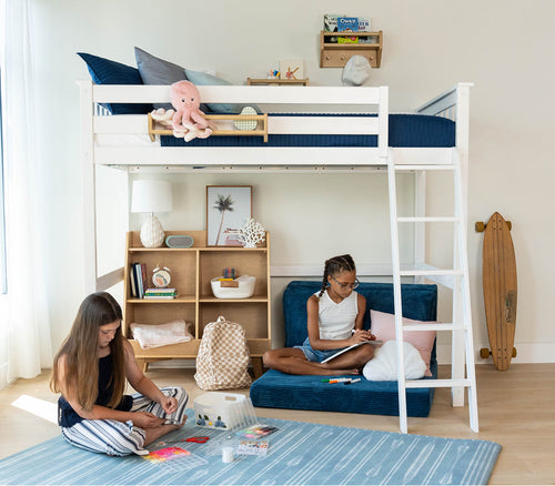 Children's room with a loft bed, bookshelf, and blue rug. Children are sitting below the loft, working on crafts.