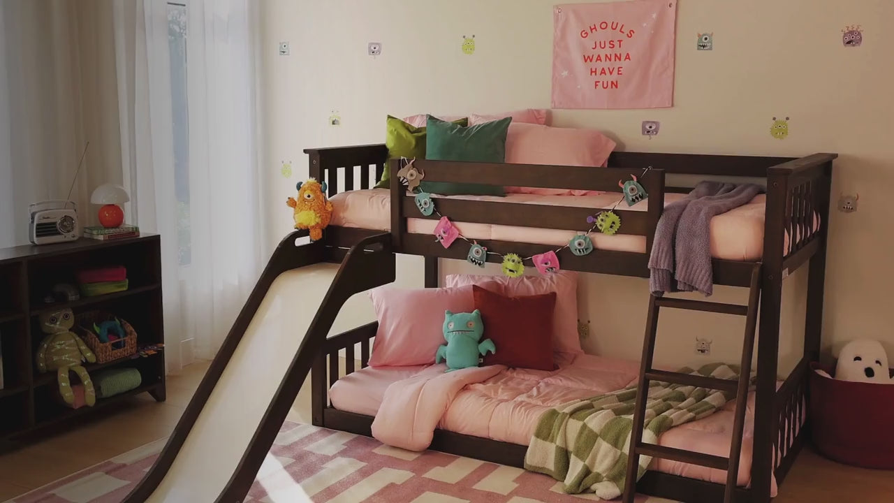 Kids in costumes playing in a room with a low loft bunk bed with slide, going down the slide, pouring candy down the slide.