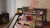 Kids in costumes playing in a room with a low loft bunk bed with slide, going down the slide, pouring candy down the slide.