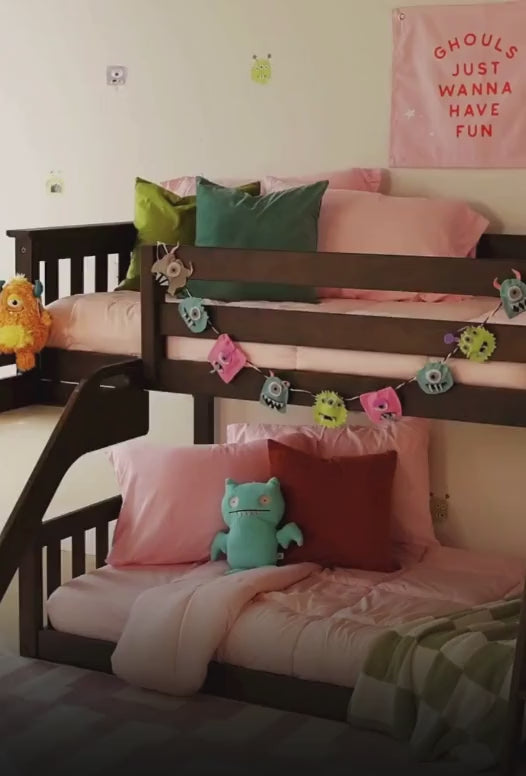 Kids in costumes playing in a room with a low loft bunk bed with slide, going down the slide, pouring candy down the slide.