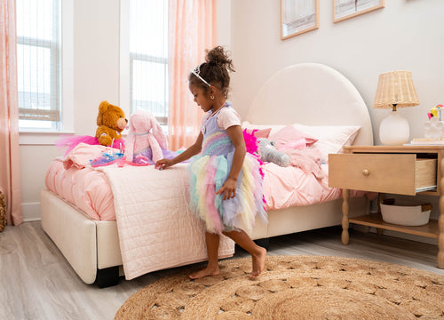 Child playing with toys on a bed in a bedroom